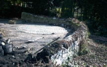 Verwitterte Natursteinmauer vor Wiederaufbau, von Efeuwurzeln zerst
